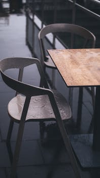 Wooden table and chairs at a wet outdoor café in Ankara, Türkiye. Perfect for rainy day moods.