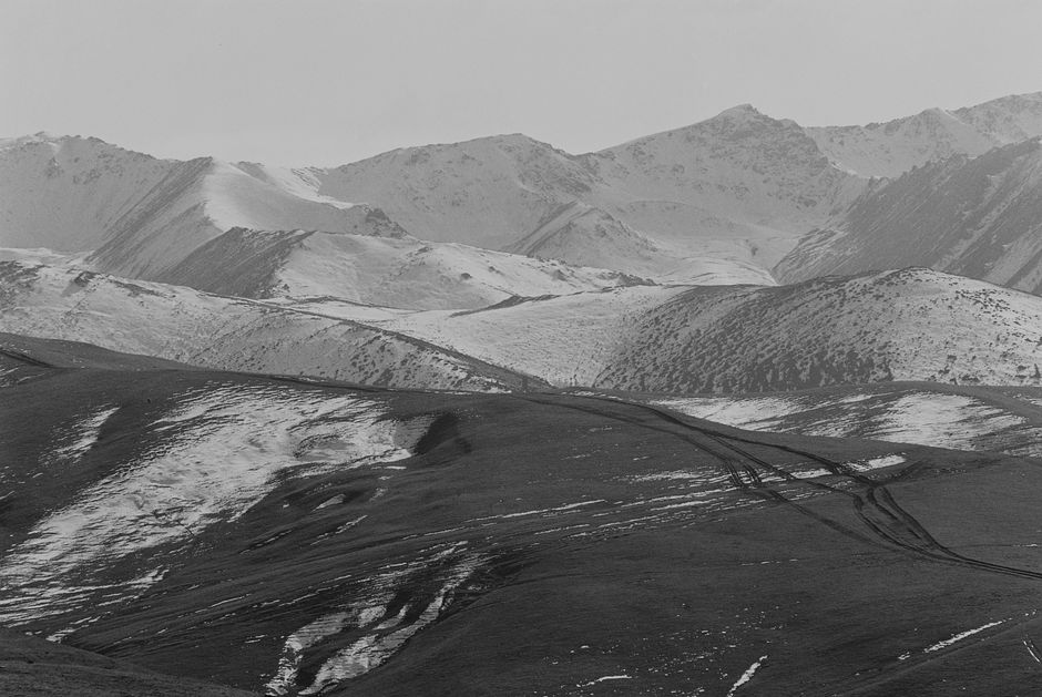A breathtaking view of snowy mountain peaks and barren terrain in Almaty, Kazakhstan.