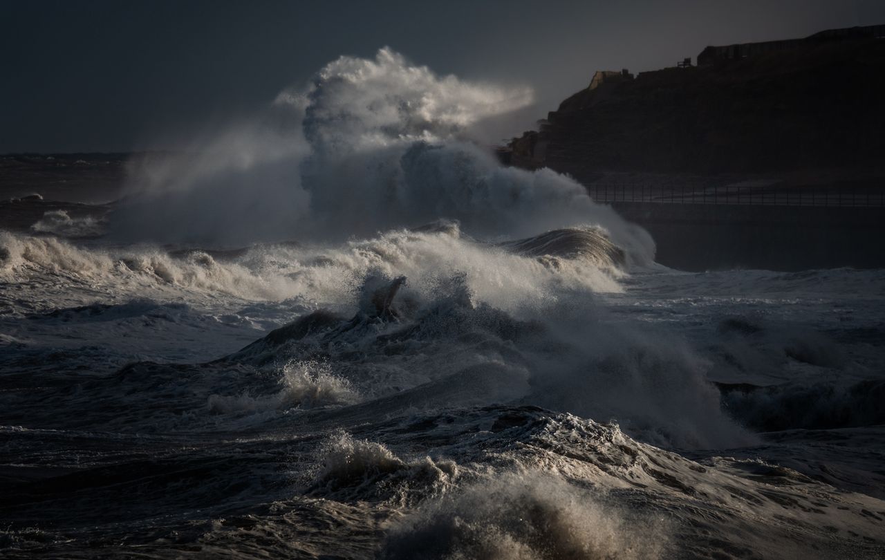 powerful ocean waves crashing with dramatic force against rugged coast