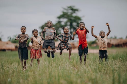 Group of Children Jumping Midair While Posing for a Photo 