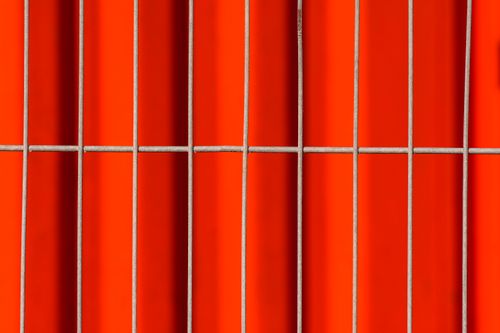Free Close-up of an abstract pattern with vibrant red tiles and metal grids, creating a striking visual impact. Stock Photo