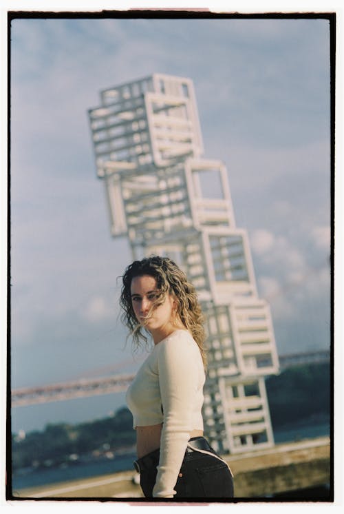 Woman in White Cropped Top Posing by Modern Art Installation