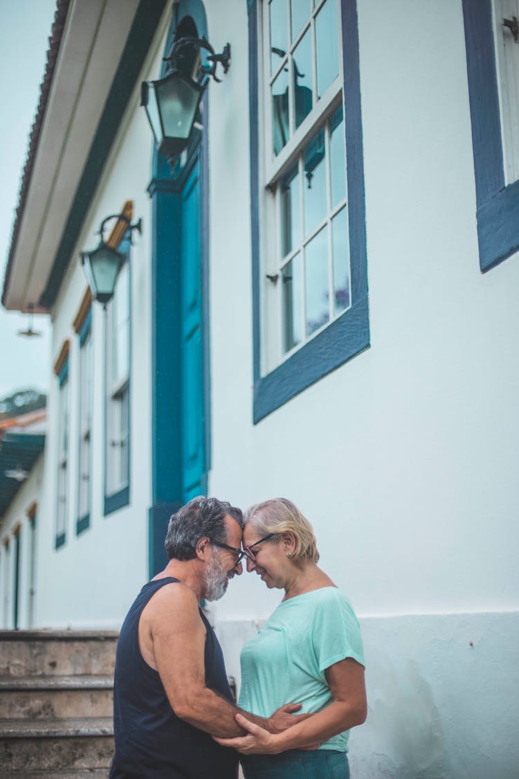 Man And Woman Standing Beside House