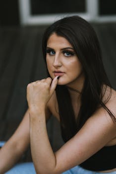 黑发女子若有所思地摆出特写肖像的姿势，展现美丽与优雅