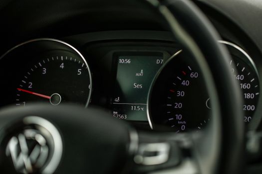 Detailed view of a car's dashboard showing speedometer and steering wheel in close-up.