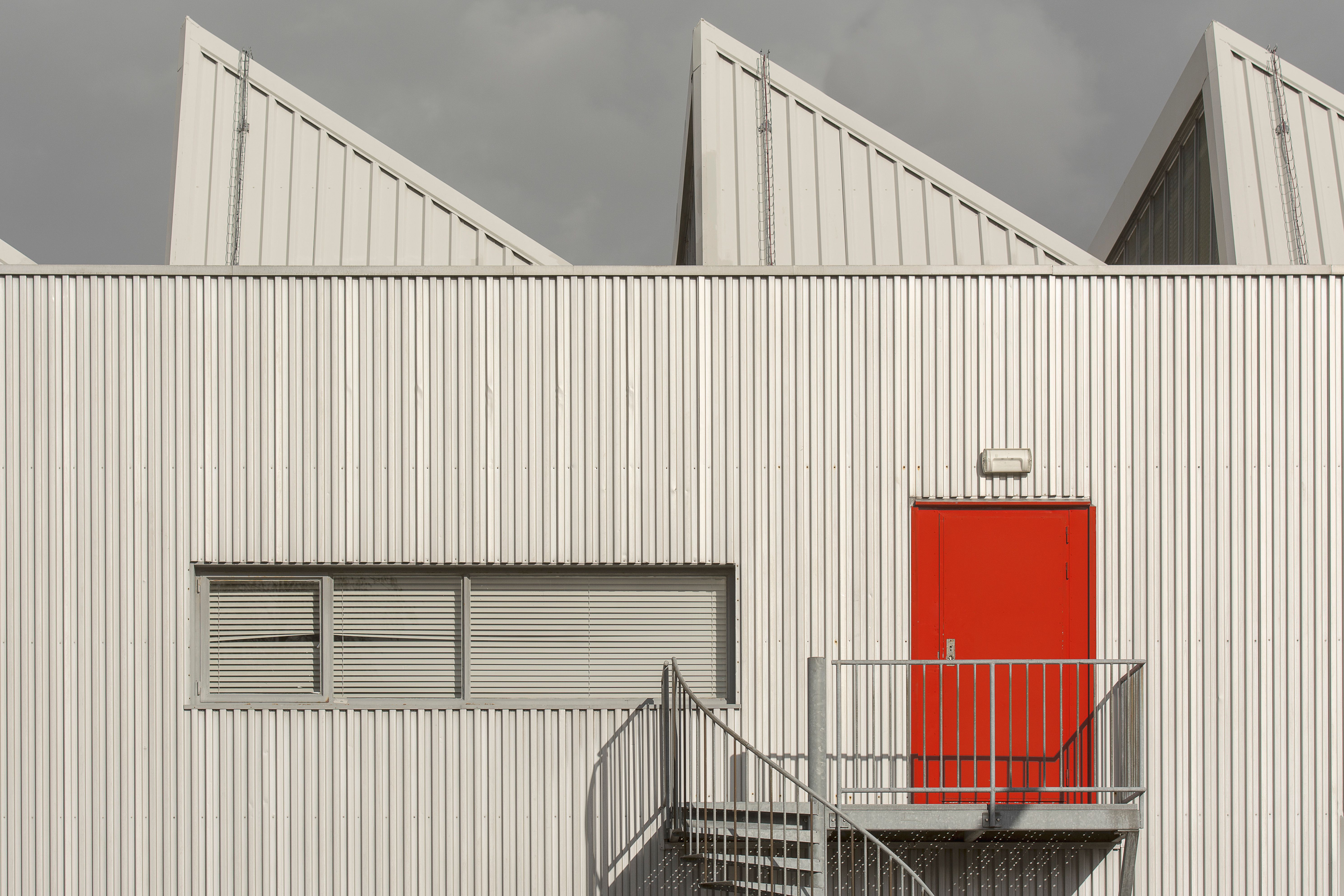 A red door is on the side of a building
