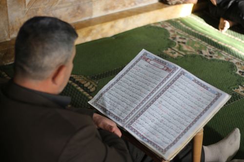 Free A man reads the Quran peacefully indoors, reflecting on spirituality and tradition. Stock Photo