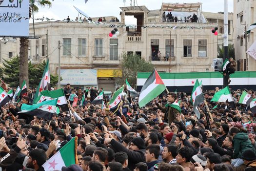 Thousands gather in Idlib, Syria, waving flags in a powerful demonstration.