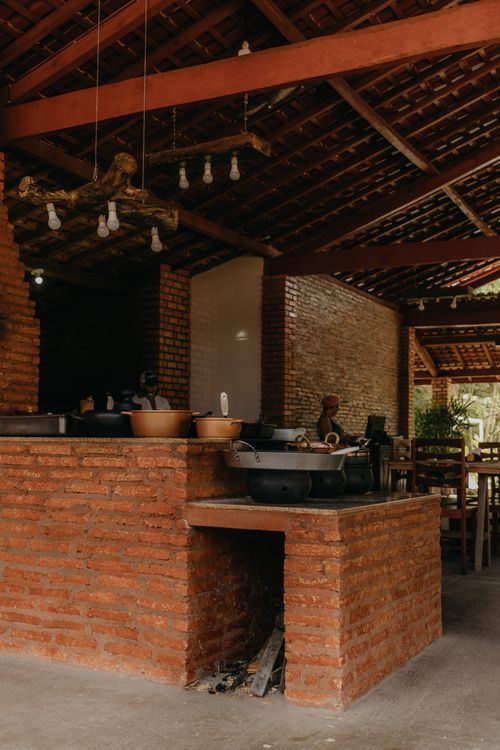 Free Rustic outdoor kitchen featuring a brick oven and dining area under a wooden ceiling. Stock Photo