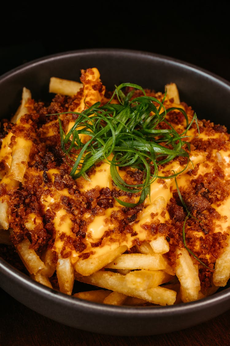 Close-up Of A Bowl Of Fries With Melted Cheese On Top 