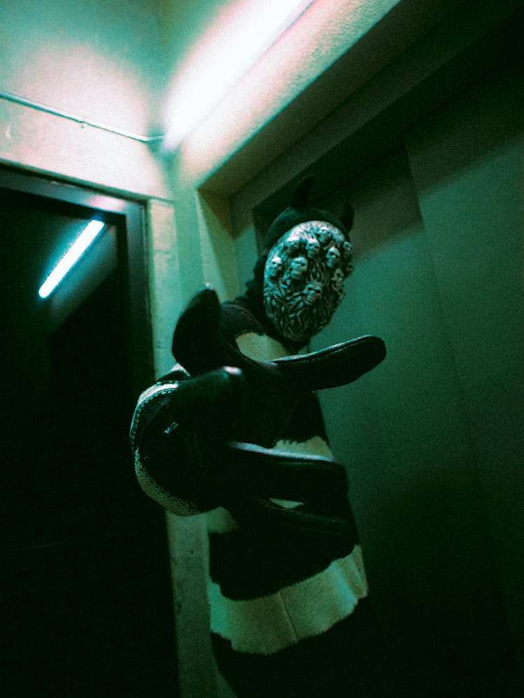 Person In A Mask Standing In Front Of The Elevator Door 