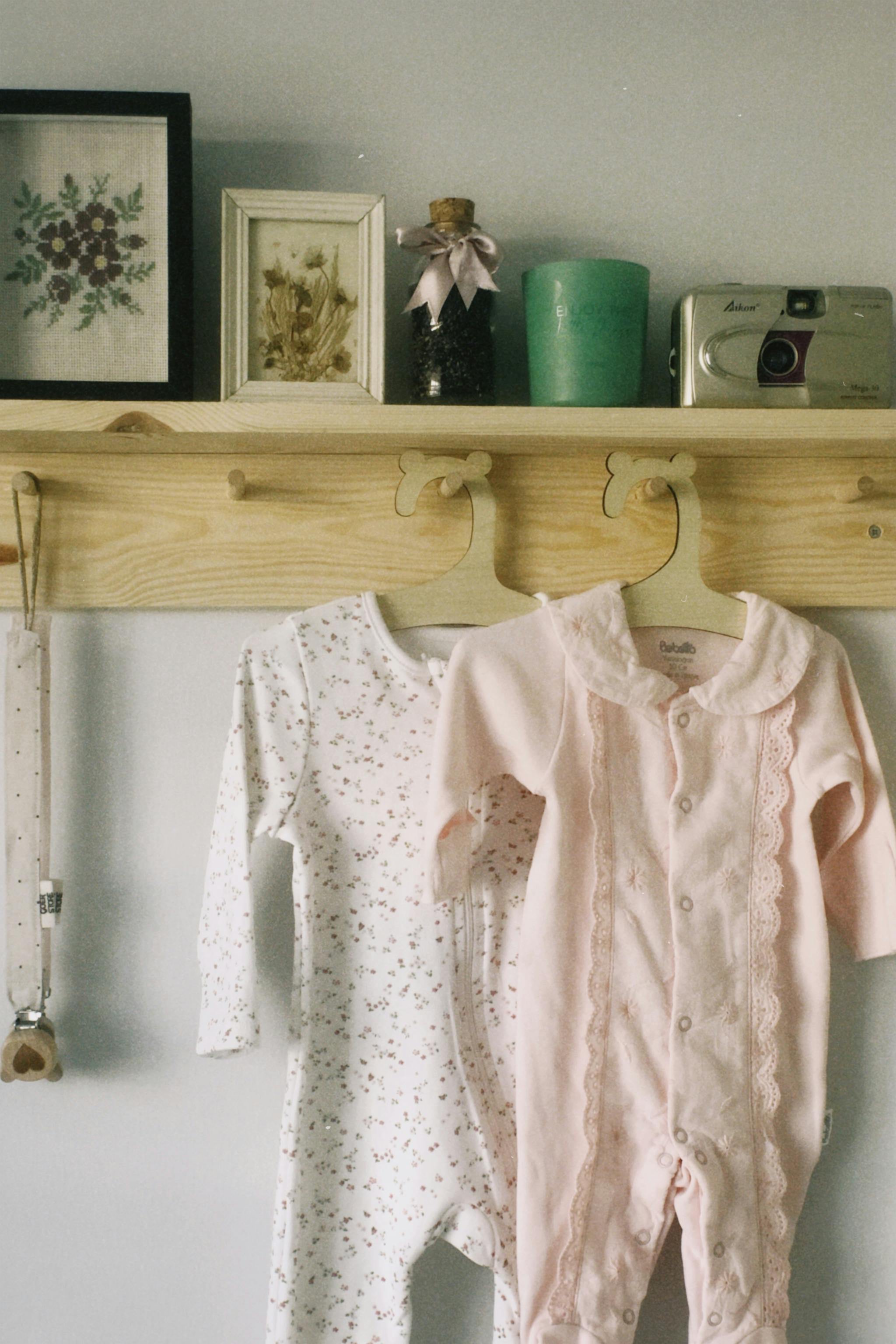 Adorable baby rompers hanging with vintage decor in a cozy, classic setting.