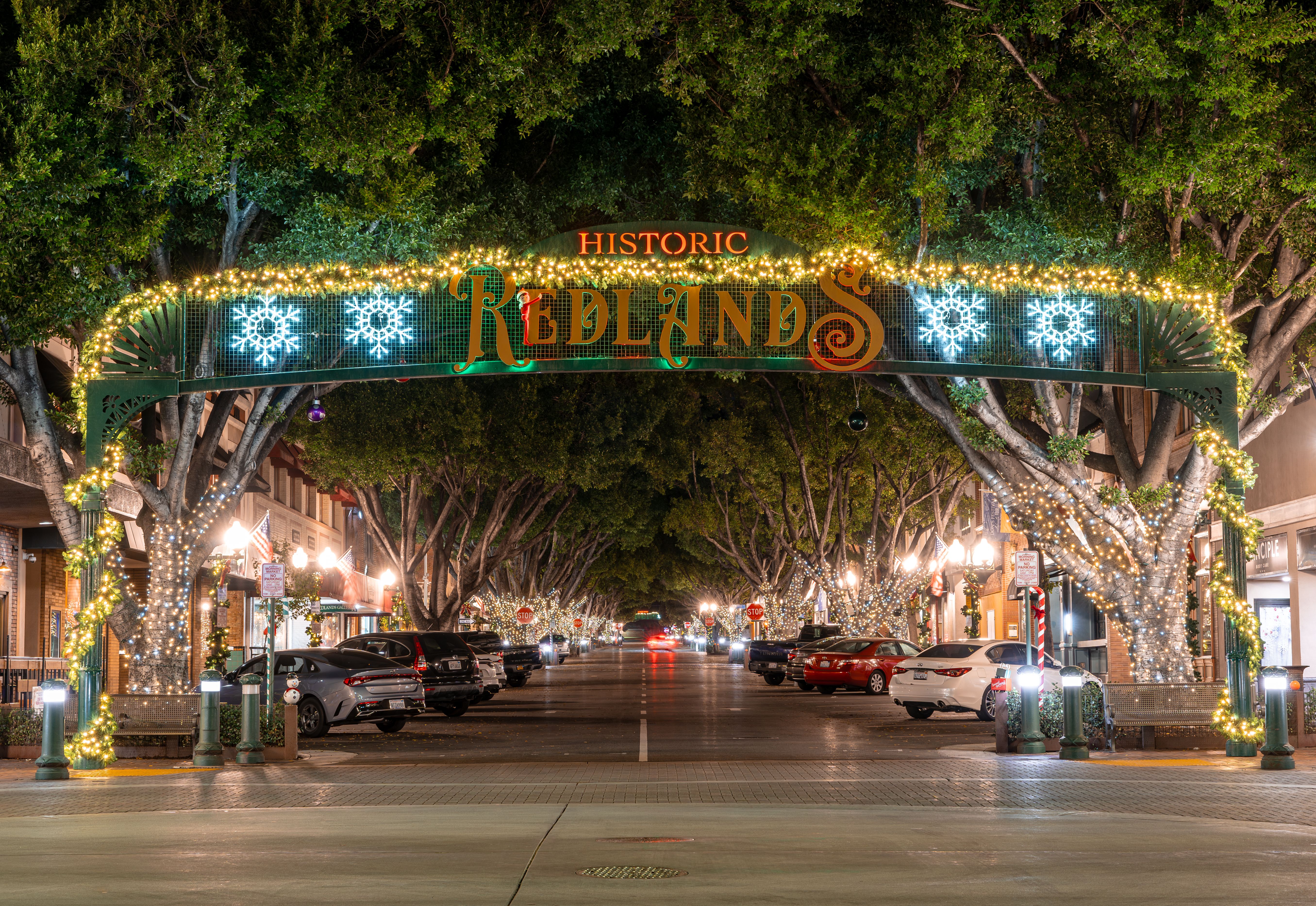 Captivating nighttime view of Historic Redlands, CA with festive lights and urban charm.