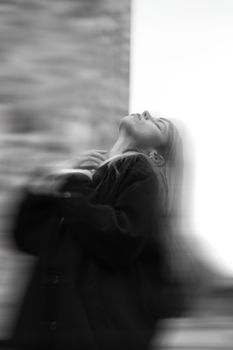 A blurred black and white portrait of a woman in a contemplative pose with eyes closed.