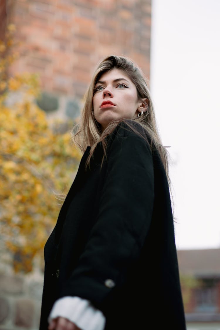 Young Fashionable Woman In A Black Coat Standing Outside 