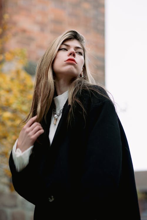 Young Fashionable Woman in a Black Coat Standing Outside 