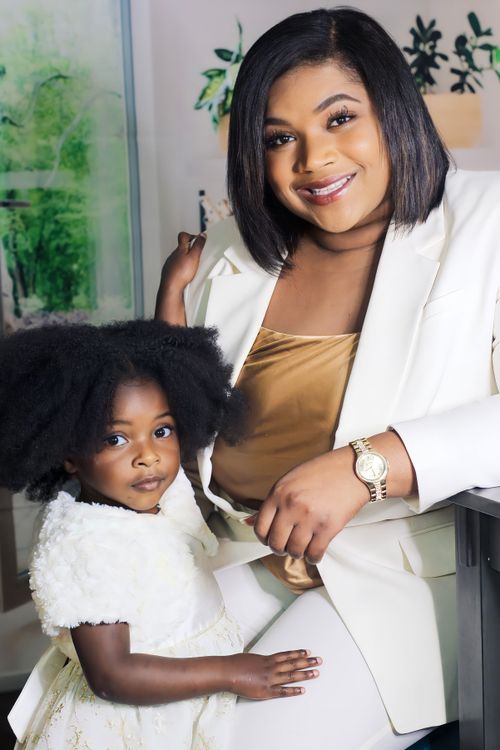 Free Charming portrait of a mother and daughter in stylish white outfits, showcasing elegance and warmth. Stock Photo