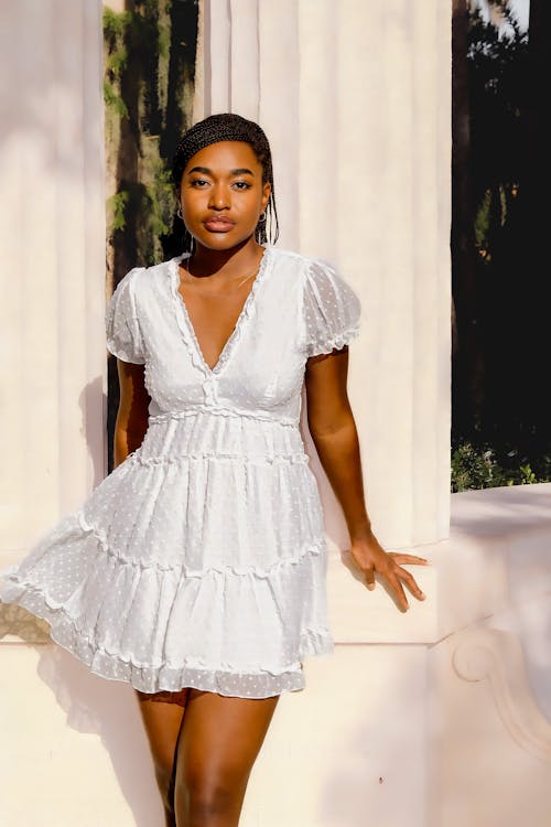 https://images.pexels.com/photos/19266149/pexels-photo-19266149/free-photo-of-model-in-a-white-v-neck-summer-mini-dress-with-ruffles-by-the-columns.jpeg?auto=compress&cs=tinysrgb&w=1260&h=750&dpr=1