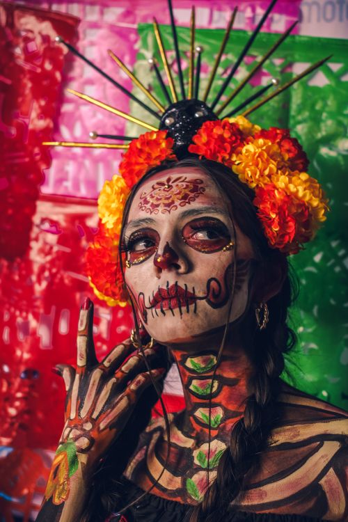 Free Close-up portrait of a woman with Dia de Muertos makeup and floral headdress. Stock Photo