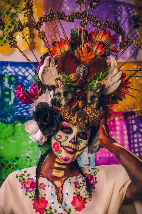 Free Colorful Day of the Dead celebration with intricate face painting and floral headdress. Vibrant cultural expression. Stock Photo