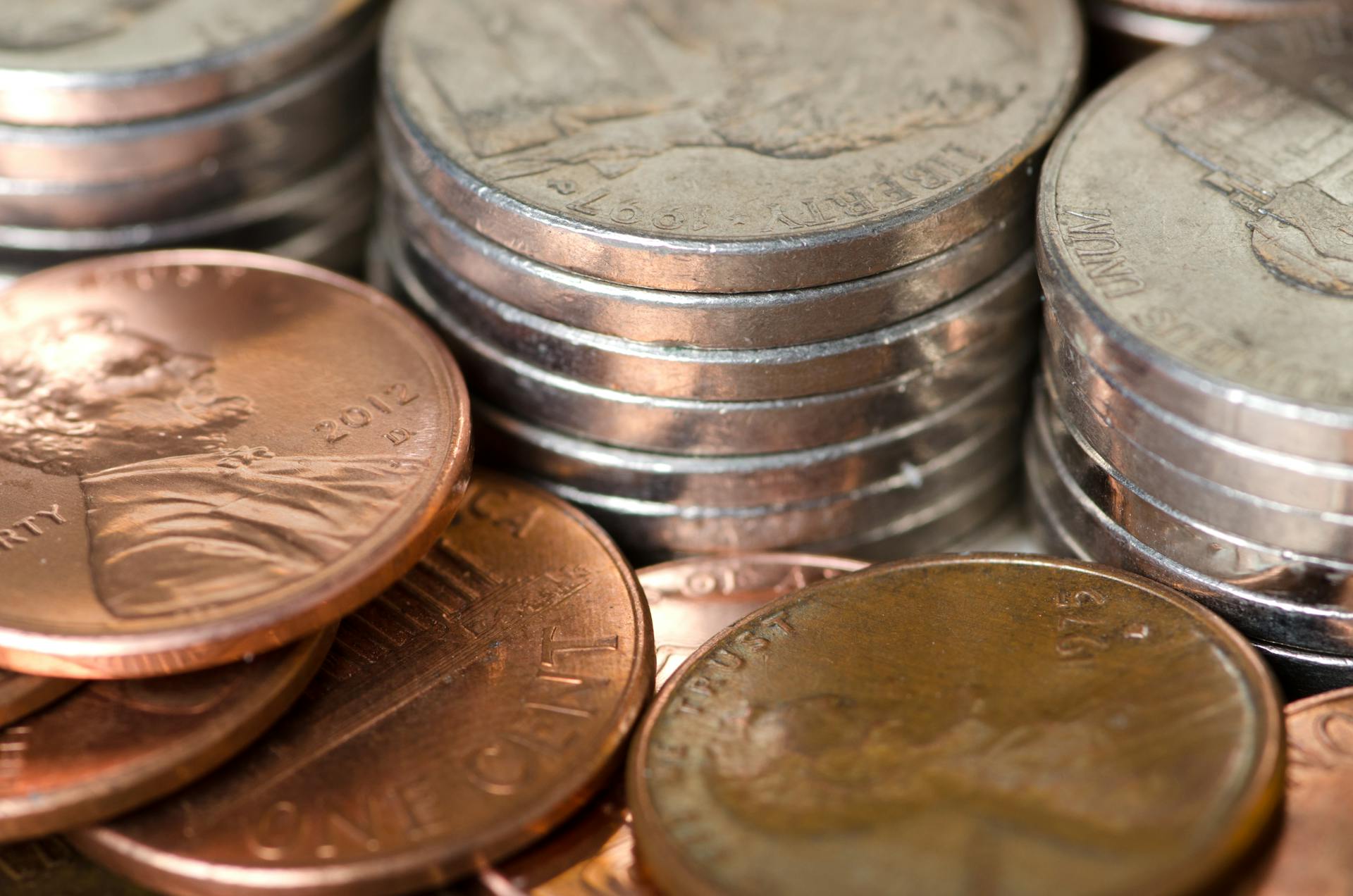 Detailed image of stacked American coins including pennies and nickels, representing savings and finance.