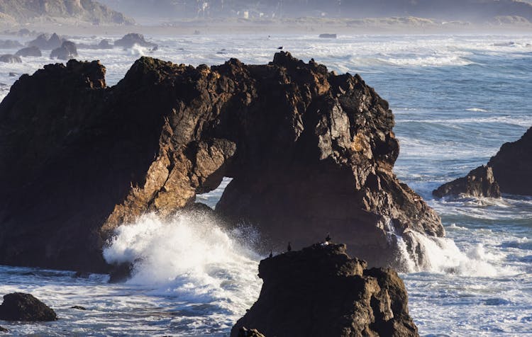 Wave Under Rocks On Sea Shore