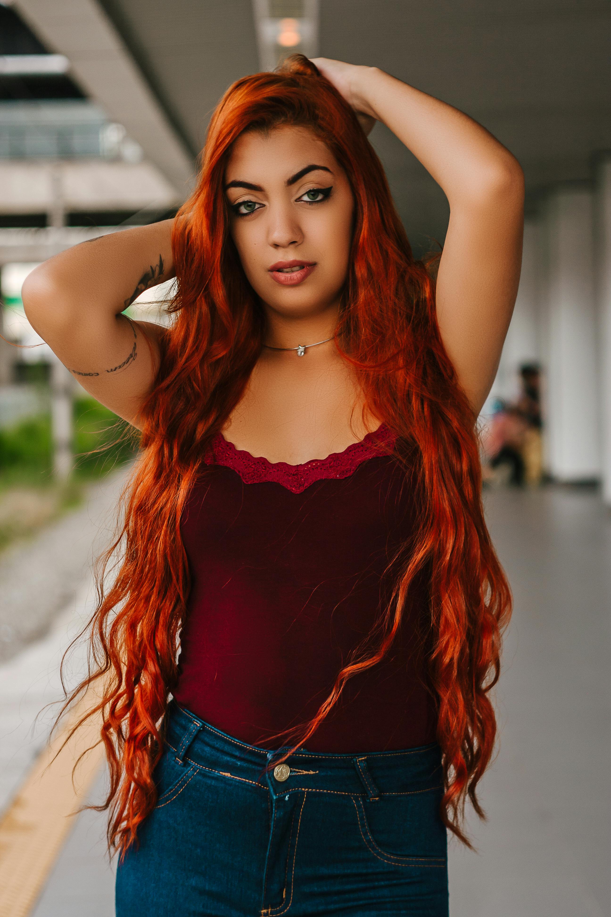 一位红发醒目、衣着时尚的女性自信地摆着姿势