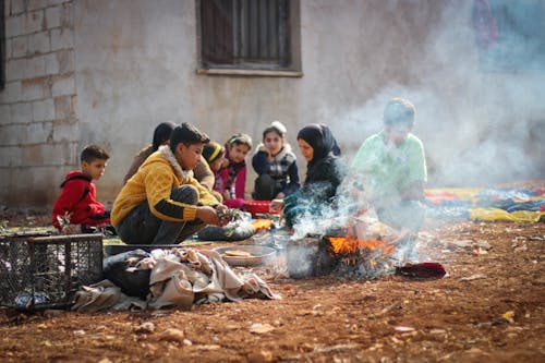 People Sitting by Bonfire in a Village 