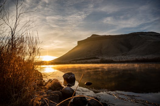 在僻静的山湖上，日出宁静，倒影朦胧，轮廓崎岖