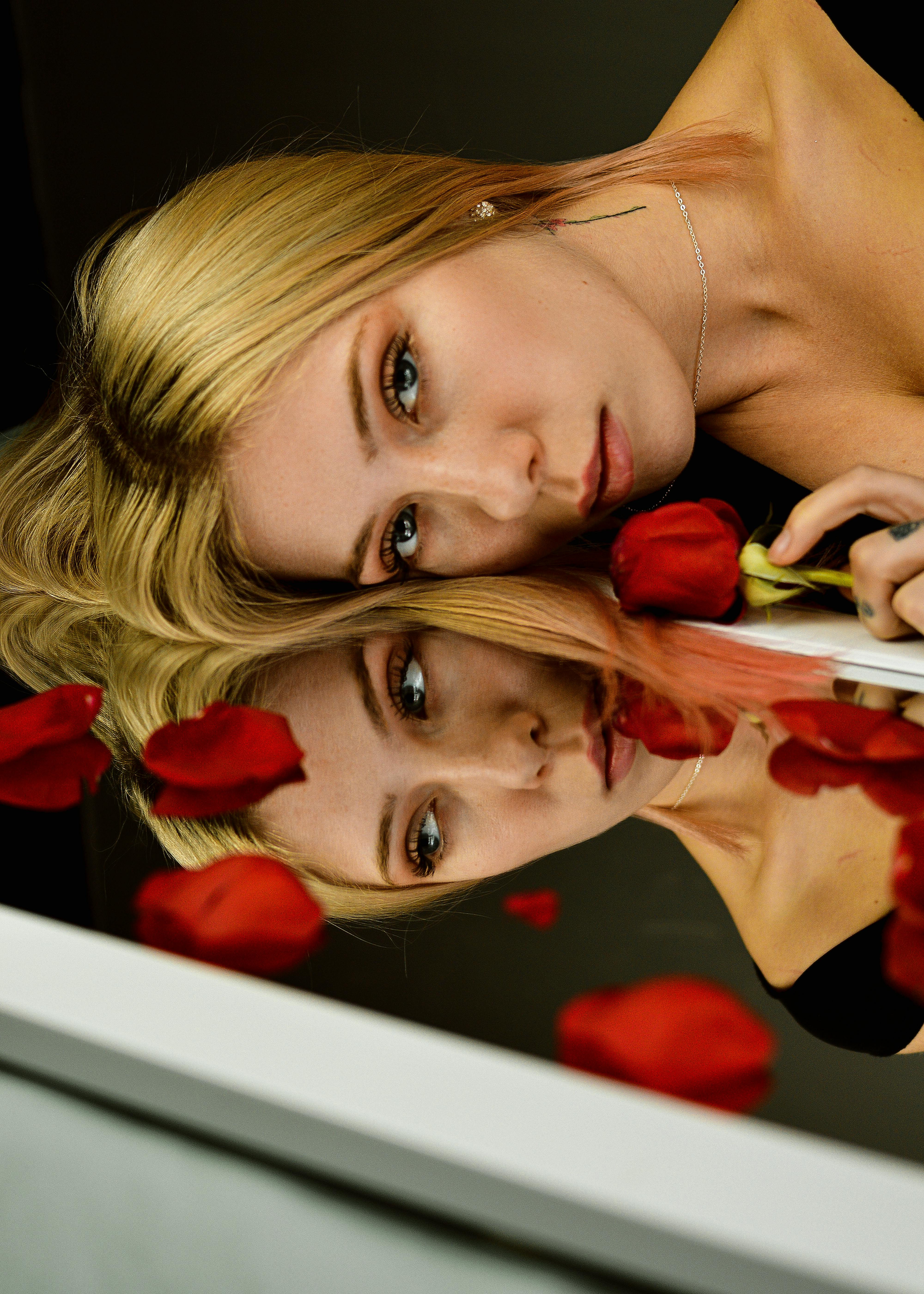 红玫瑰花瓣包围的表面上，映出了一个美丽的女人