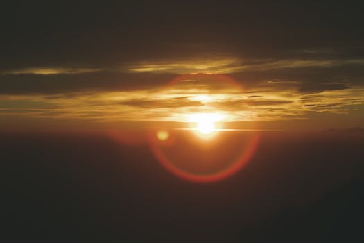 Beautiful sunset with vibrant sun and clouds over Campo dei Fiori, Italy.