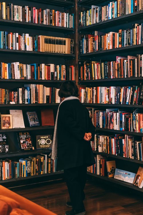 Free Person browsing a cozy bookstore corner filled with a variety of books. Stock Photo