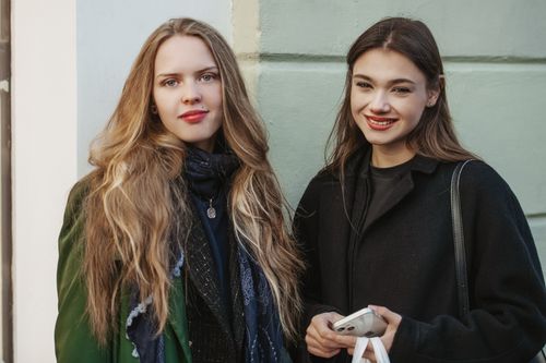 Free Two young women smiling in stylish coats, capturing autumn fashion and friendship. Stock Photo