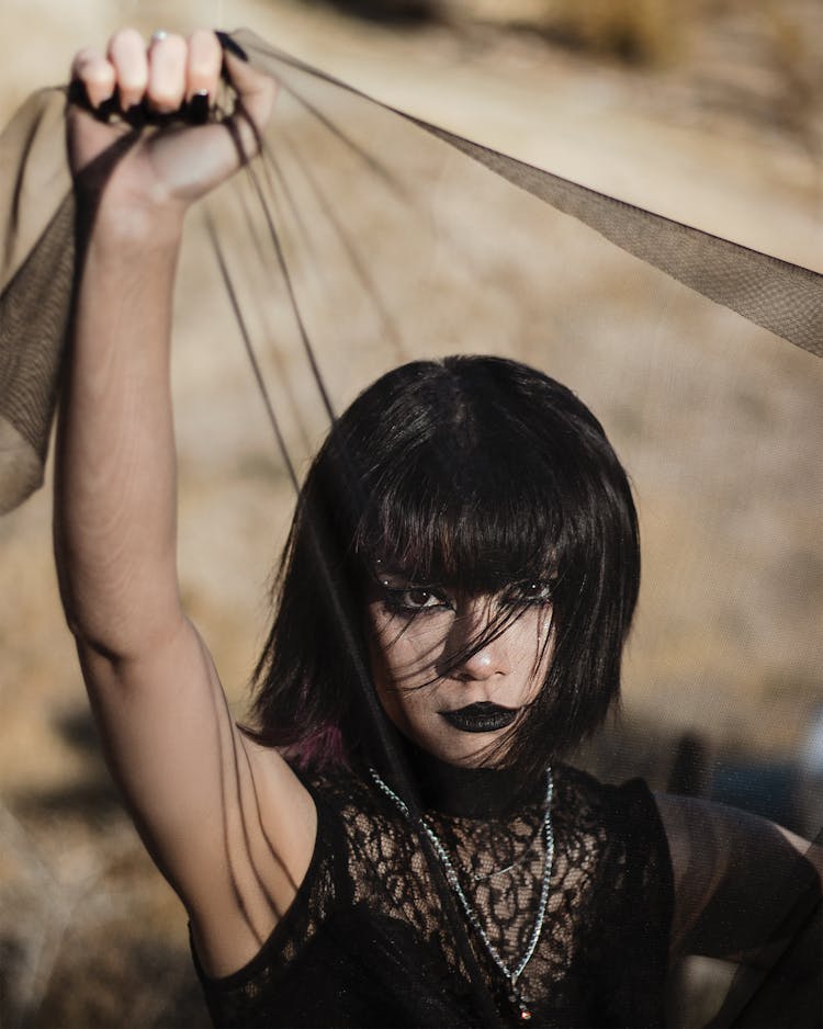 Goth Woman In A Black Dress Holding Chiffon Scarf