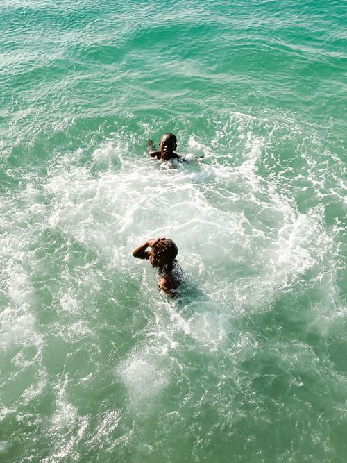 Free Two children having fun swimming in the ocean on a sunny day. Perfect summer activity. Stock Photo