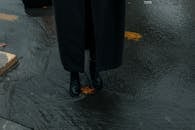 Autumn Leaf on Wet Road between Shoes of Person