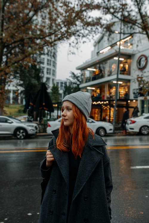 Red Haired Woman in Gray Beanie Standing on Street