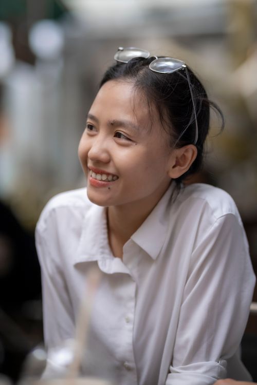 Free Portrait of a smiling woman in a white shirt with eyeglasses indoors, reflecting a cheerful and casual mood. Stock Photo