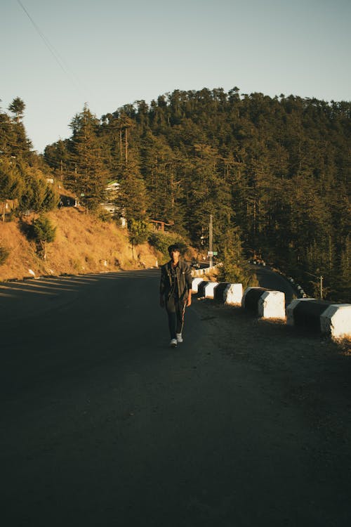 Man Walking along Mountain Road