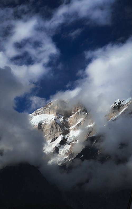 Snow Mountain Peak Seen through Light Clouds