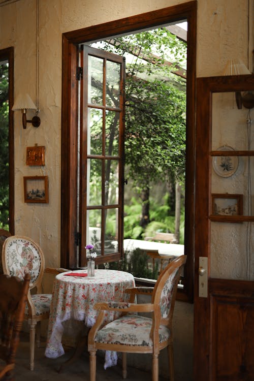 Table and Chairs near Open Windows in House