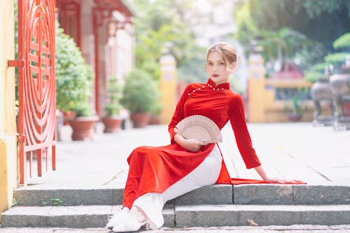 Woman in Elegant Red Dress Holding a Fan