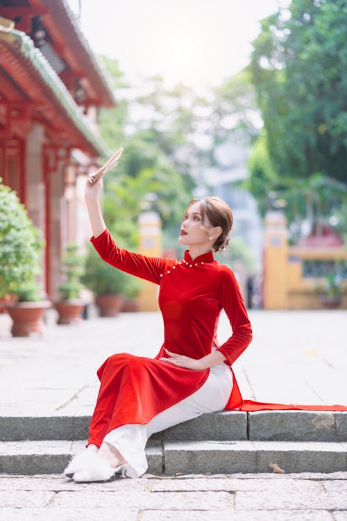 Beautiful Woman in Traditional Red Dress Posing with Hand Fan