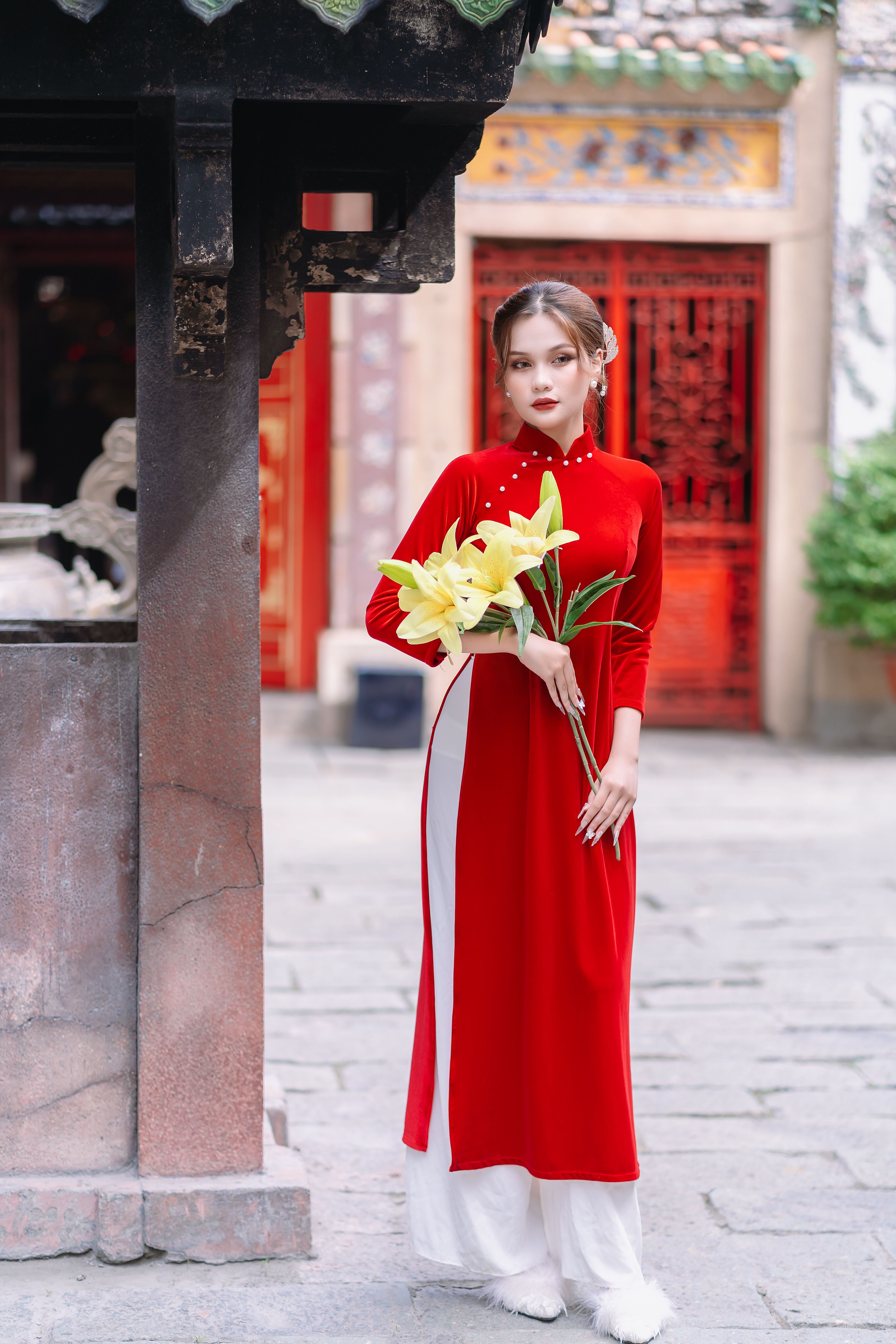 Beautiful Model in Red Dress Posing with Bouquet of Yellow Flowers  Free  Stock Photo