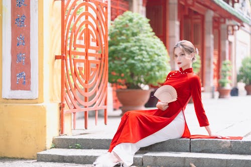 Woman in Red Qipao Dress Posing on Steps