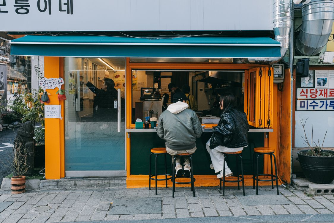 ソウルの街角のカフェで並んで座る二人