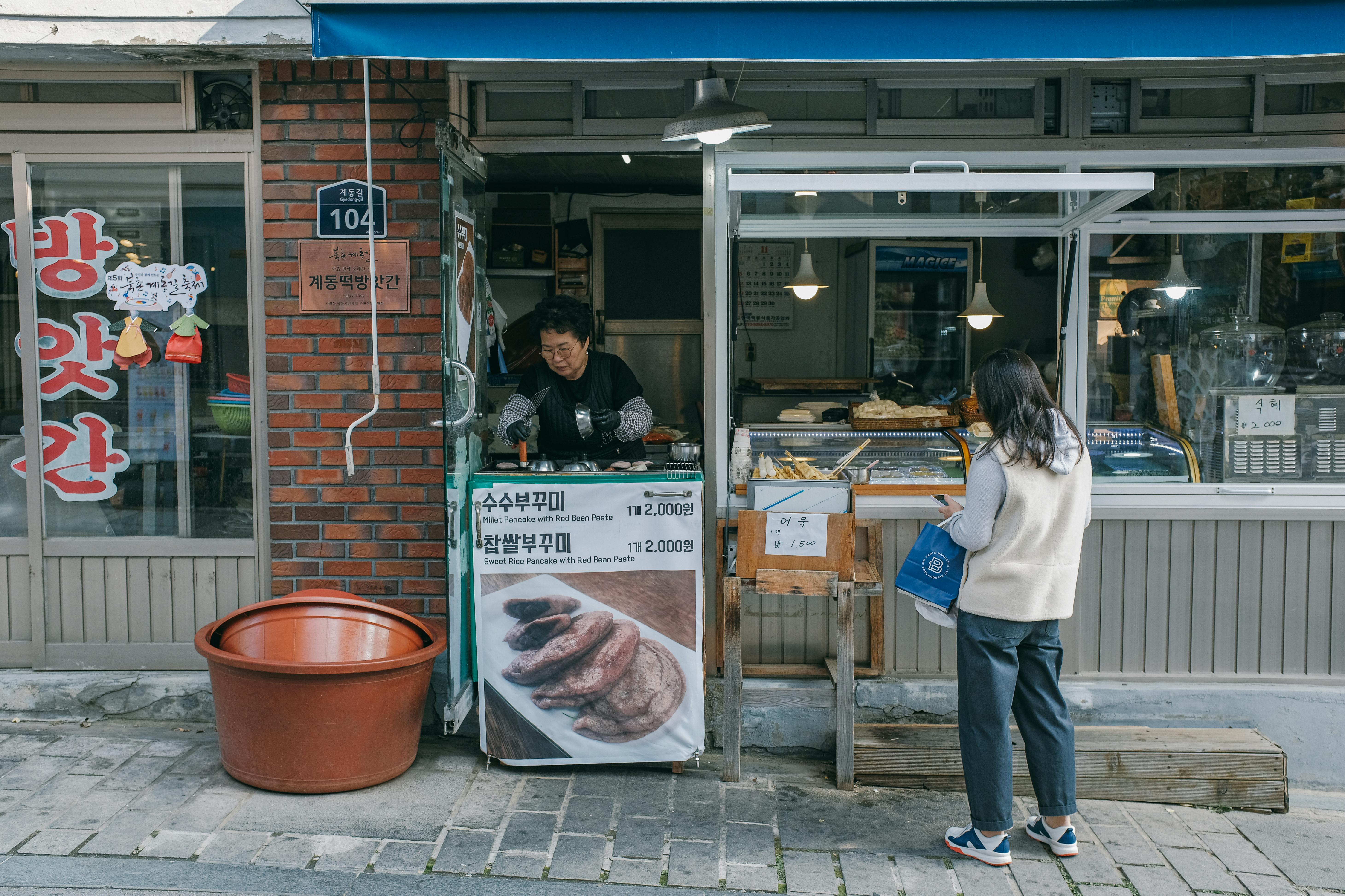 woman standing in front of a street food restaurant in city