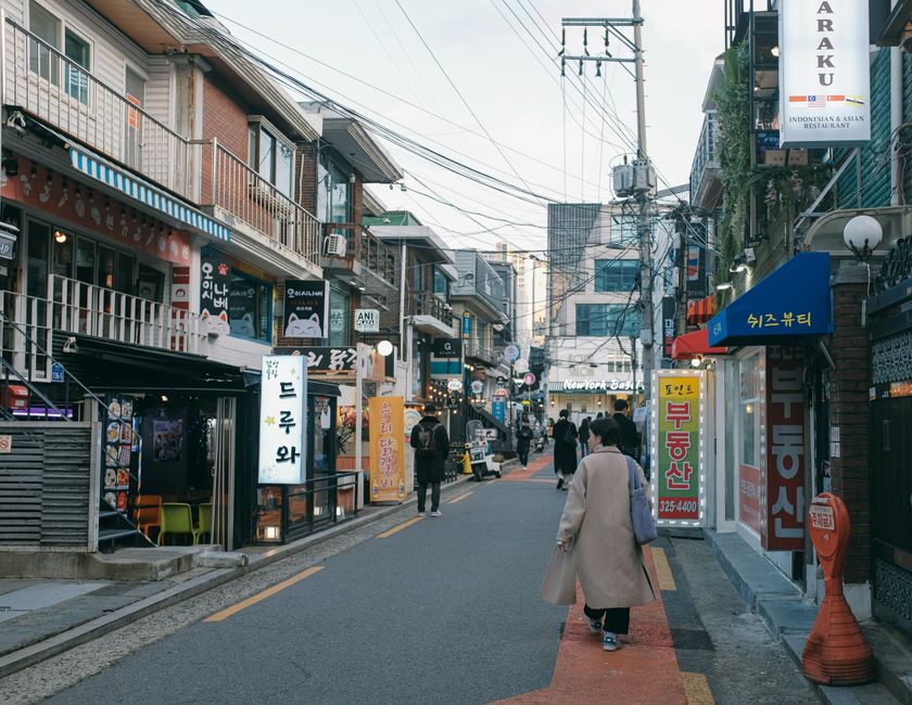 Busy pedestrian shopping street in Myeongdong Seoul with stores and restaurants