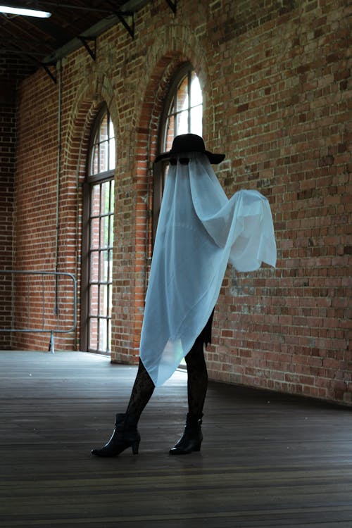Woman Dressed as a Ghost Wearing Heels, Hat and Sunglasses