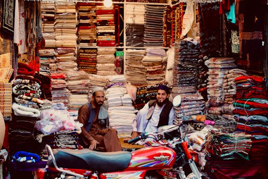 Vibrant textile market showcasing diverse fabrics with two smiling sellers.